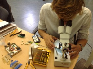 Wouter bekijkt een printplaat onder de microscoop.